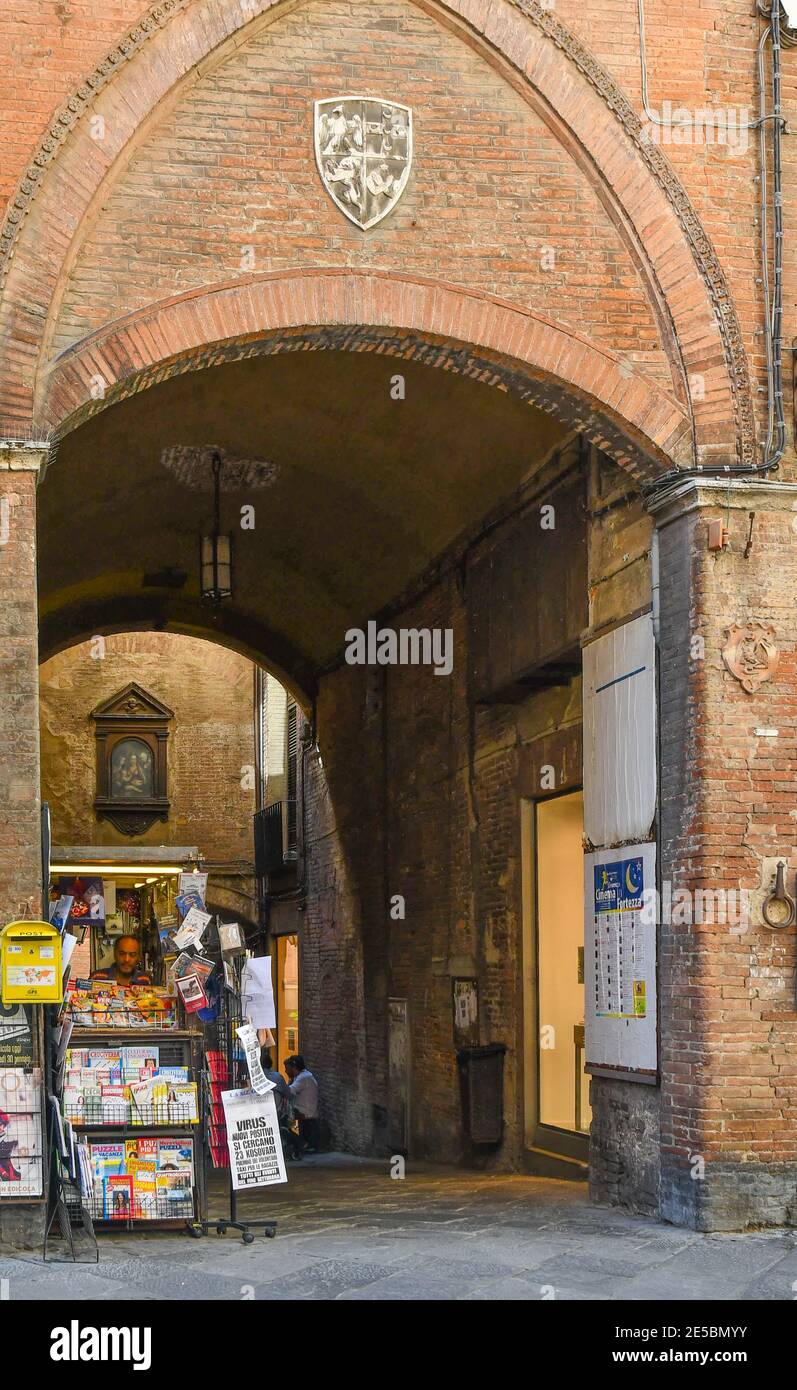Un kiosque à journaux sous l'allée voûtée Arco dei Pontani dans le centre historique de Sienne, Toscane, Italie Banque D'Images