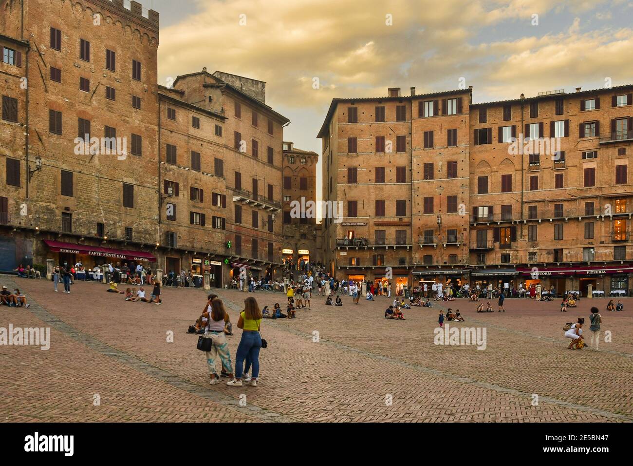 Place Piazza del Campo dans le centre historique de Sienne, site classé au patrimoine mondial de l'UNESCO, avec des gens et des touristes en été au coucher du soleil, Toscane, Italie Banque D'Images