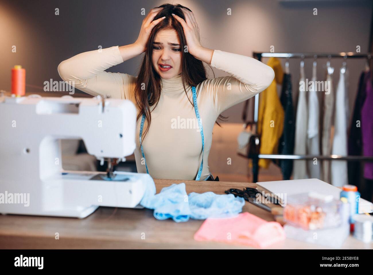 Jeune couturière femme ragoûts les vêtements sur la machine à coudre. Faire  des erreurs ou quelque chose est allé mal couturière dans l'atelier.  Création de vêtements en ligne Photo Stock - Alamy