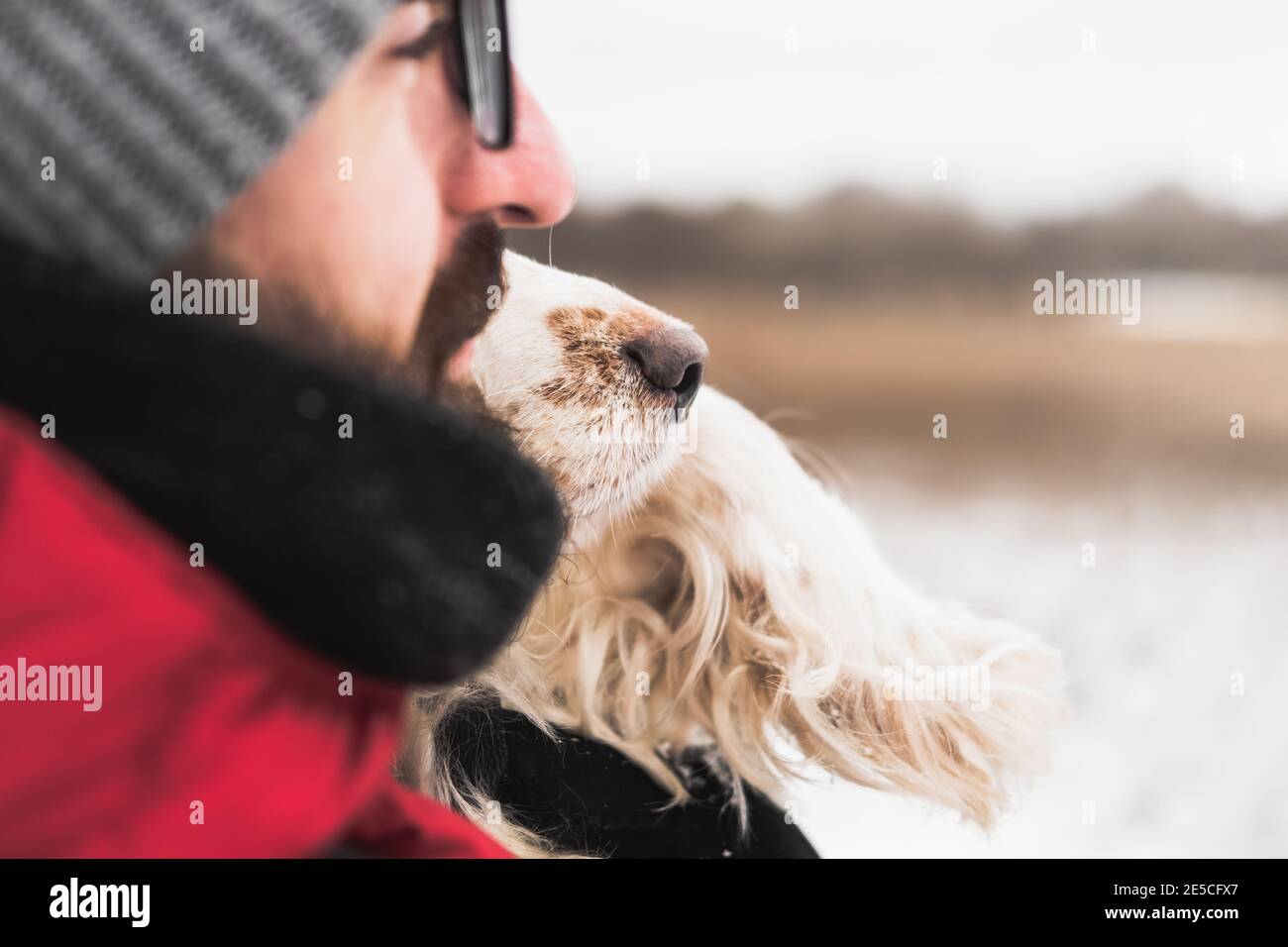 Nez de chien à côté du visage d'un homme à l'extérieur. Mode de vie actif, passer du bon temps avec les animaux en hiver, faible profondeur de champ Banque D'Images