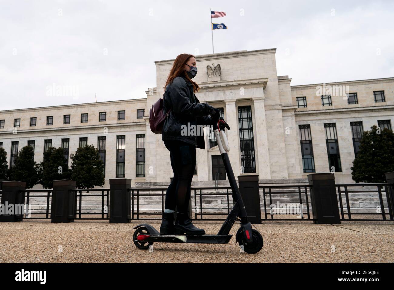 Washington, États-Unis. 27 janvier 2021. Le 27 janvier 2021, une femme portant un masque passe devant la Réserve fédérale américaine à Washington, DC, aux États-Unis. La Réserve fédérale américaine a maintenu mercredi son taux d'intérêt de référence inchangé au niveau record de près de zéro, alors que le pays se débat avec le ralentissement de la reprise économique dans le contexte de la flambée des cas de COVID-19. Credit: Liu Jie/Xinhua/Alay Live News Banque D'Images