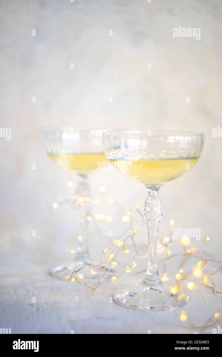 Deux verres de champagne avec lumières de fées sur une table Banque D'Images