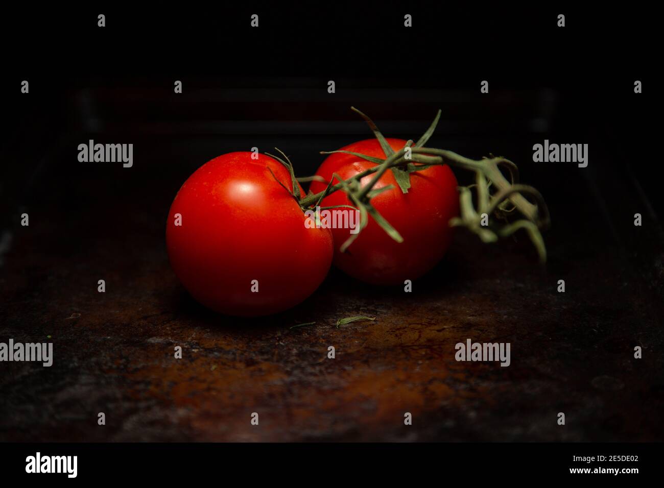 Deux tomates vigne sur une table en bois Banque D'Images