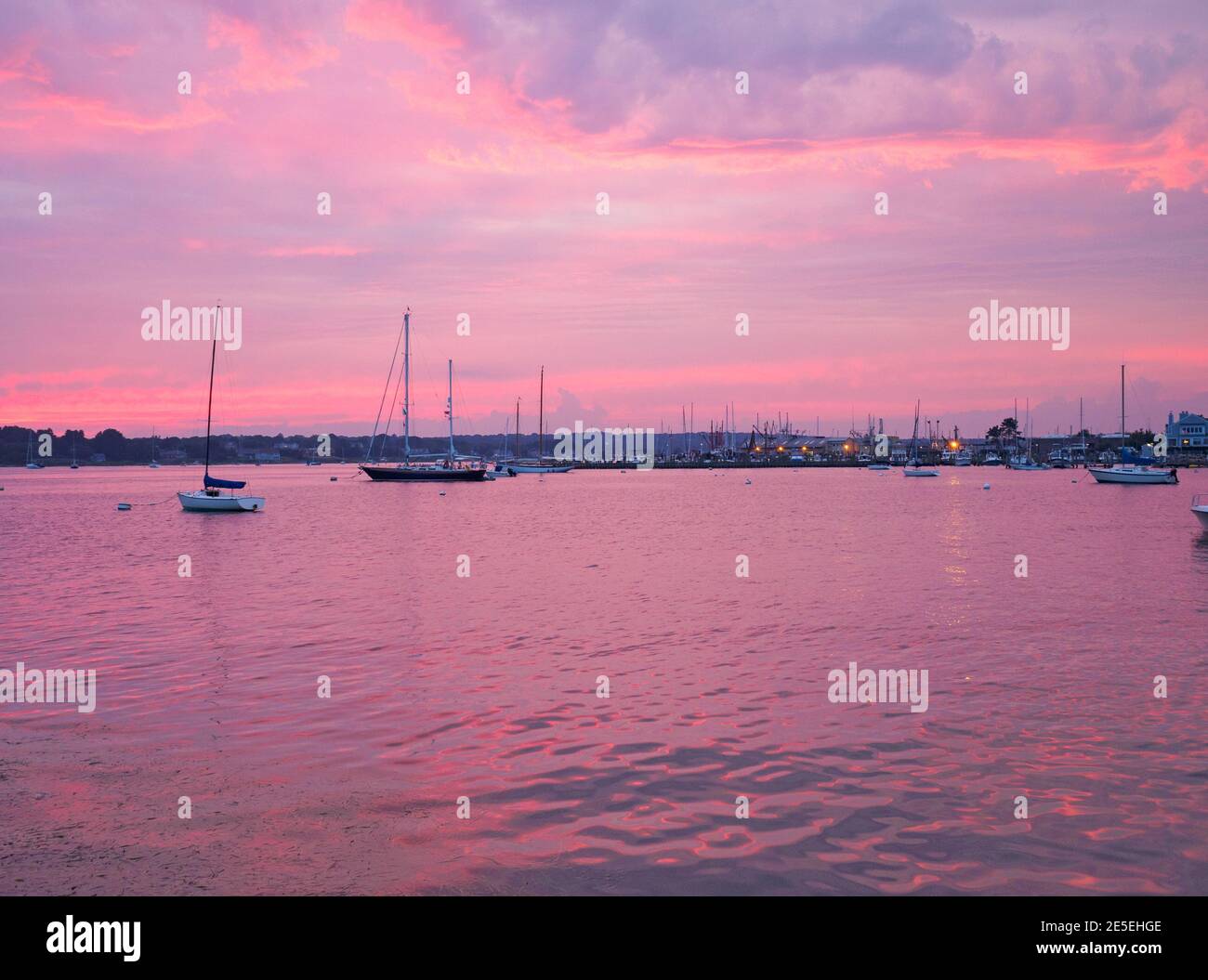 Voiliers dans le port à l'heure bleue juste après le coucher du soleil avec des nuages roses et pourpres dans le ciel et l'eau pourpre, Stonington, Connecticut USA. Stoningto Banque D'Images