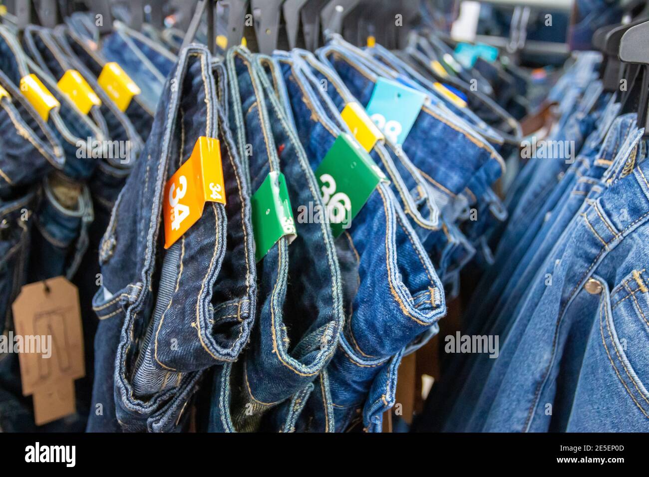 Gros plan de nombreux jeans accrochés sur un porte-vêtements. Rangée de  pantalons Jean denim accroché dans le placard. Concept d'achat , vente ,  shopping et jeans mode Photo Stock - Alamy