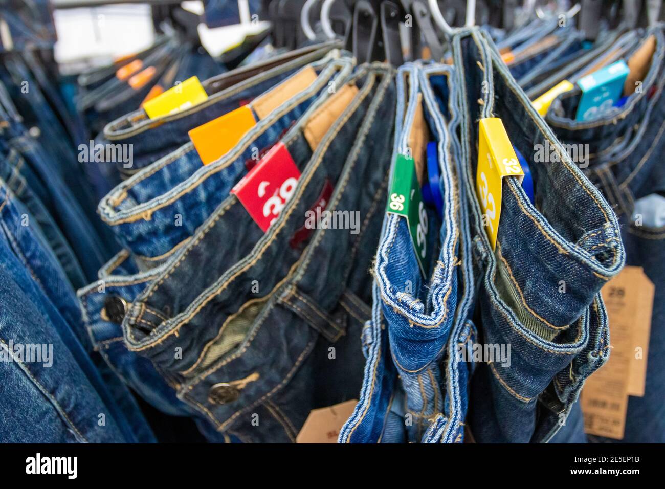 Gros plan de nombreux jeans accrochés sur un porte-vêtements. Rangée de  pantalons Jean denim accroché dans le placard. Concept d'achat , vente ,  shopping et jeans mode Photo Stock - Alamy