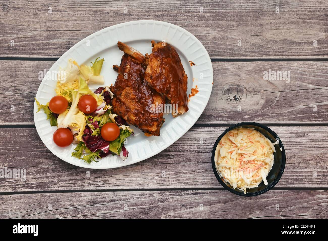 Plat de côtes de barbecue avec salade et tomates cerises Banque D'Images
