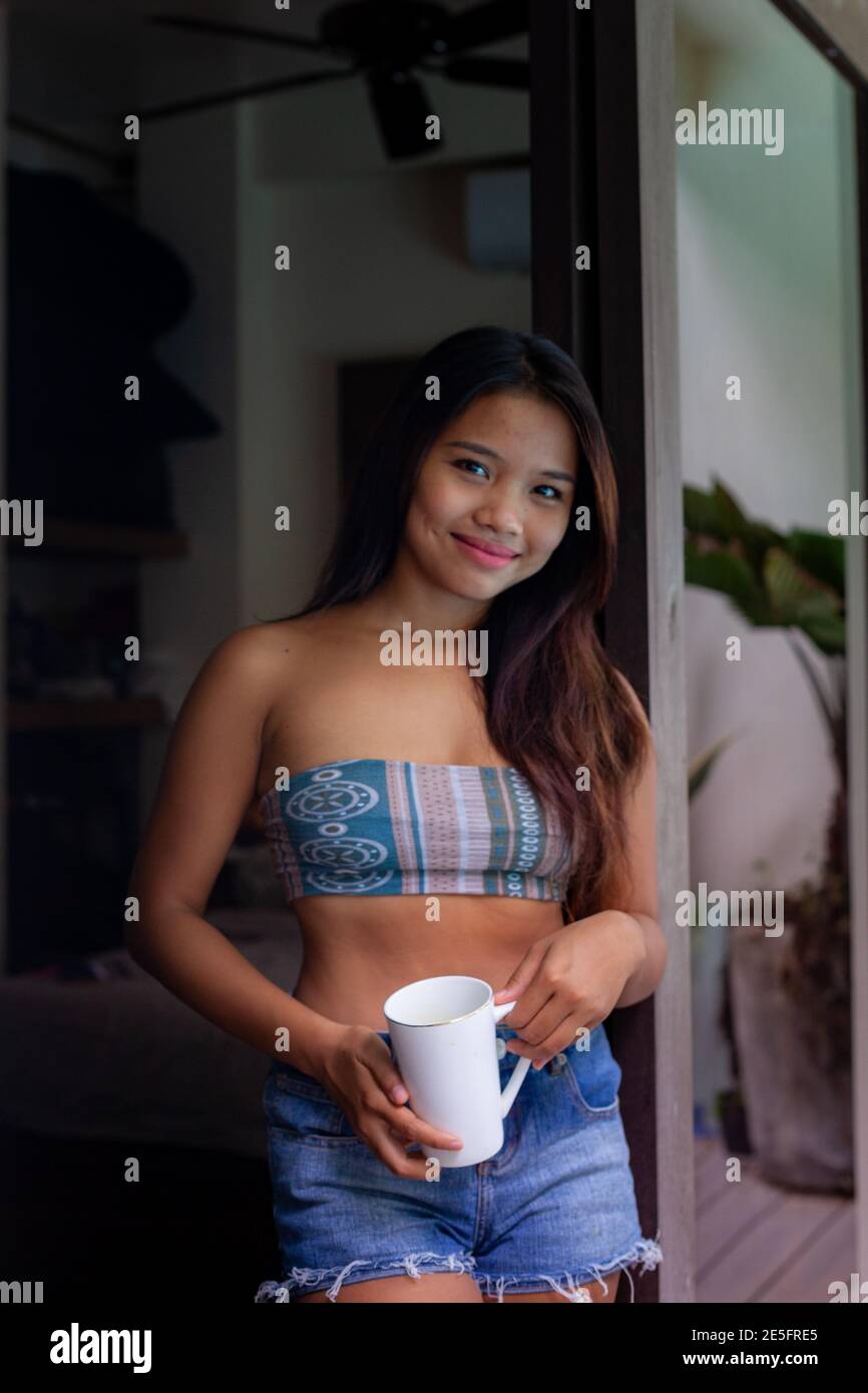 Asiatique jeune et mignonne fille heureuse d'avoir un café parfumé le matin à la maison, la villa ou le Resort Banque D'Images