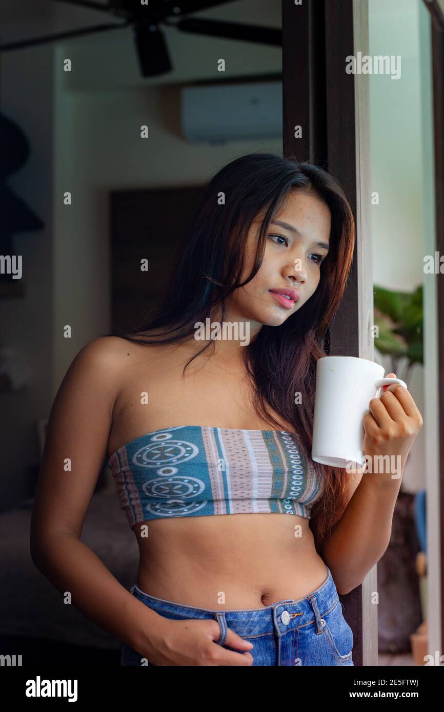 Asiatique jeune et mignonne fille heureuse d'avoir un café parfumé le matin à la maison, la villa ou le Resort Banque D'Images