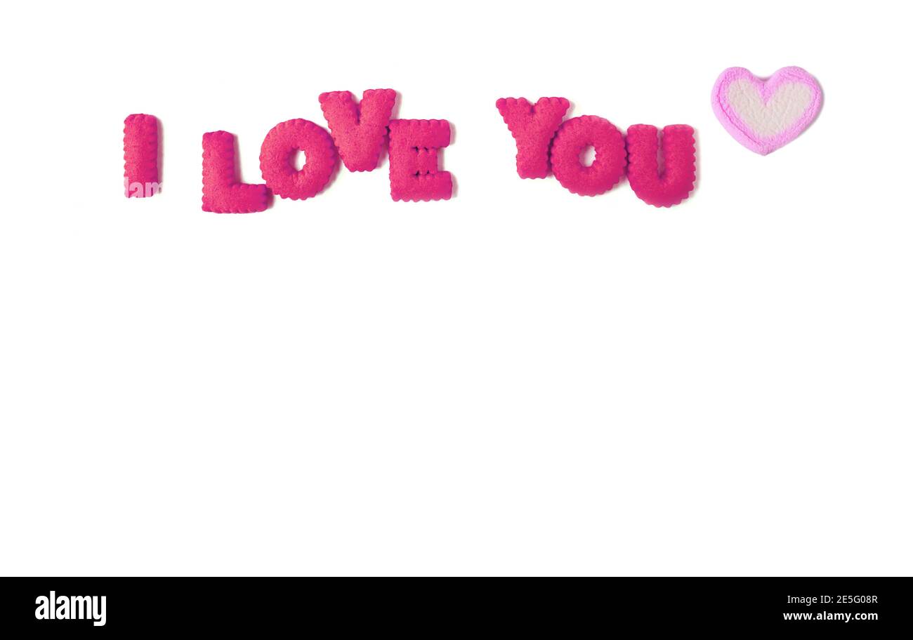 Le mot que je VOUS AIME orthographié avec l'alphabet rose chaud biscuits et bonbons guimauve rose pastel sur fond blanc Banque D'Images
