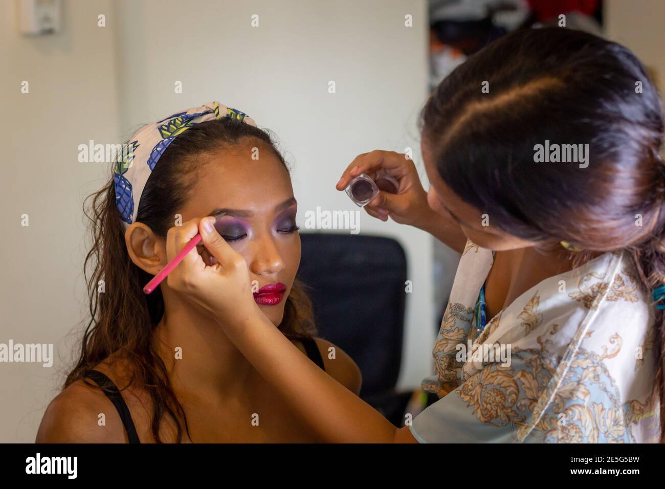 Maquilleuse jeune asiatique faire du maquillage à un asiatique Modèle Latina Banque D'Images
