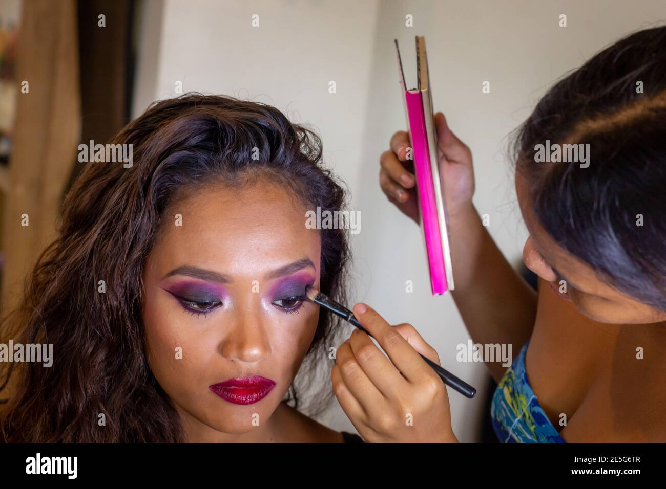Maquilleuse jeune asiatique faire du maquillage à un asiatique Modèle Latina Banque D'Images