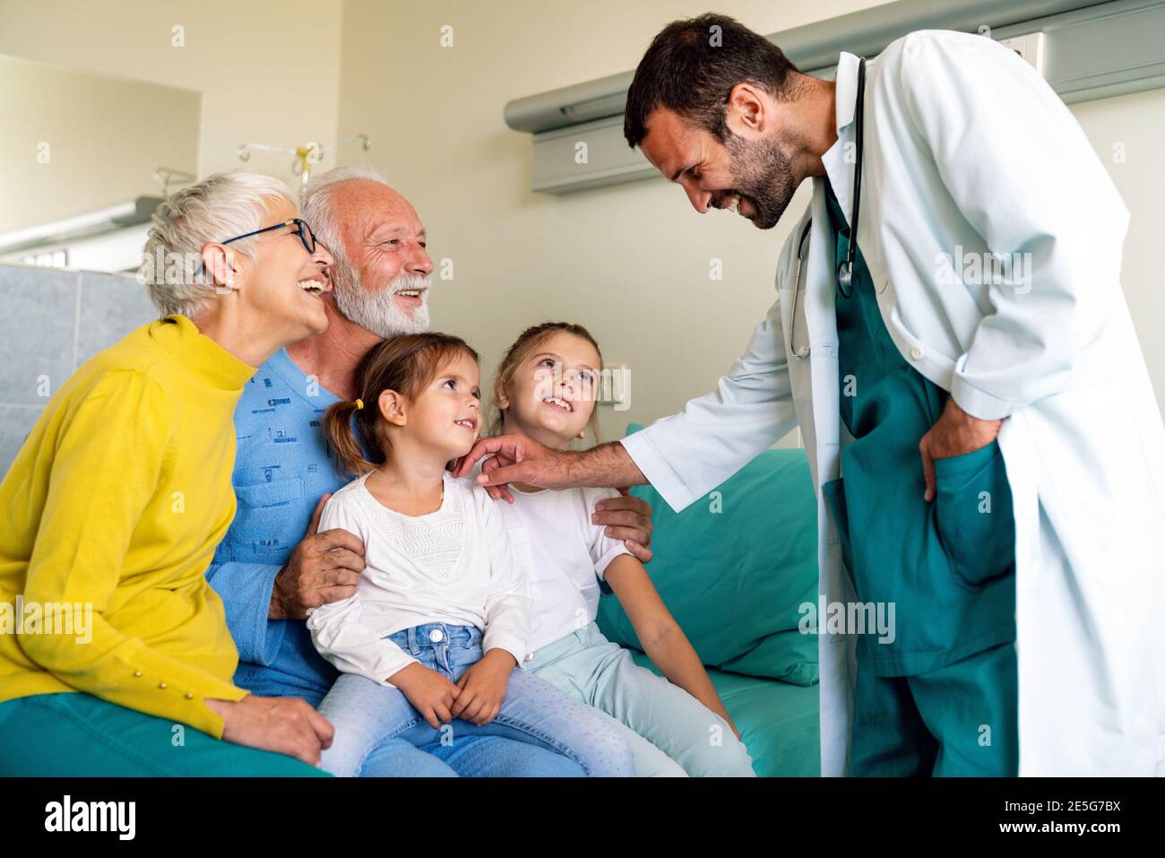 Famille rendant visite à un homme mature à l'hôpital. Santé, retraité, concept de soutien familial Banque D'Images