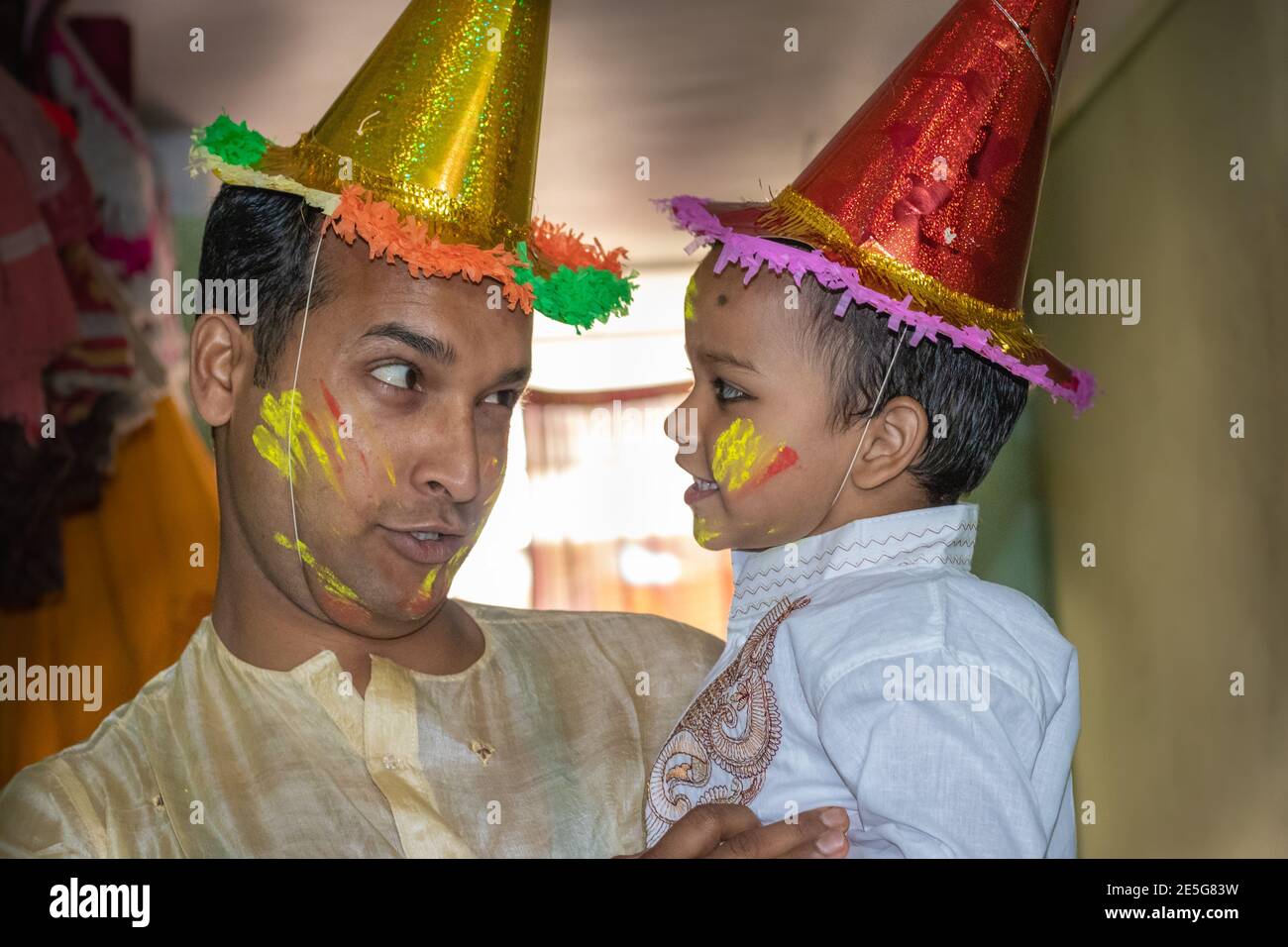 père et fille appréciant la fête des holi le festival des couleurs gros plan est l'expression de l'enfant tout en appréciant les holi indiens Banque D'Images