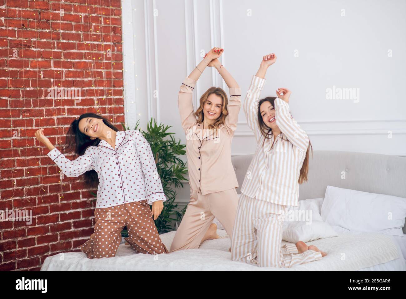 Trois jeunes filles ayant une fête de pyjama et se sentant joyeuse Photo  Stock - Alamy