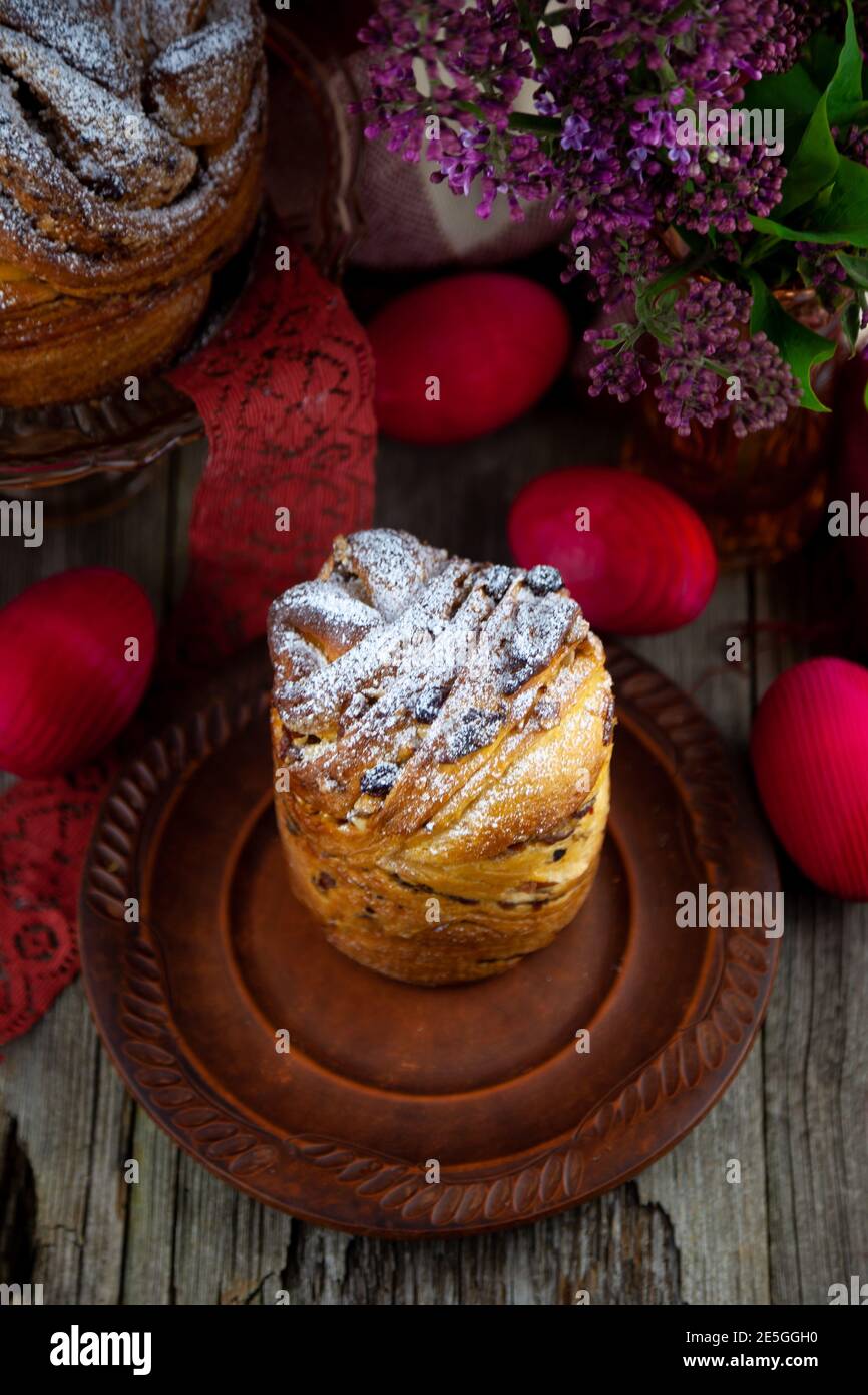 Kraffin gâteau de Pâques. Kraffins aux raisins secs, fruits confits et graines de pavot, arrosés de sucre en poudre. Gros plan de gâteau maison. Brut. Banque D'Images