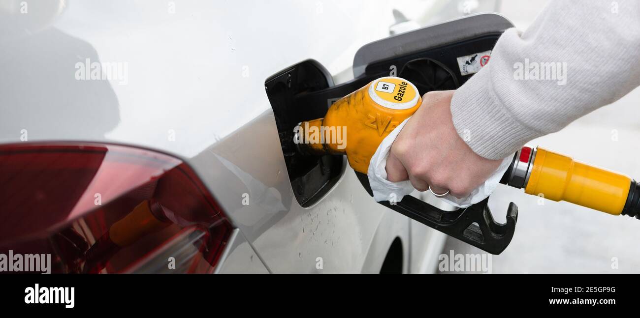 Bannière d'un homme manipulant avec un papier un jaune pompage de carburant pour faire le plein d'une voiture grise Banque D'Images