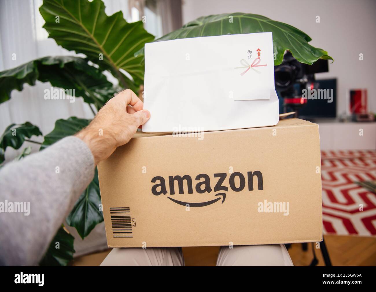 Paris, France - 22 novembre 2018: POV main mâle tenant unboxing le nouveau  colis de Amazon.jp Japon et hiéroglyphic texte sur le paquet d'emballage de  cadeau traduit comme heureux anniversaire célébration Photo