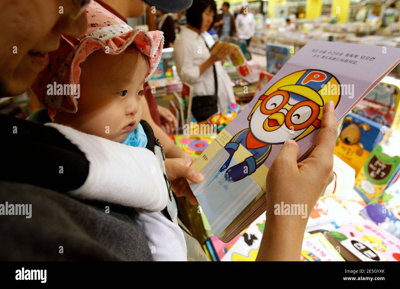 A baby looks at the cartoon character Pororo at a book store in Seoul May  16, 2011. He's roly poly, wears a yellow aviator's helmet and orange  goggles, and is everywhere in