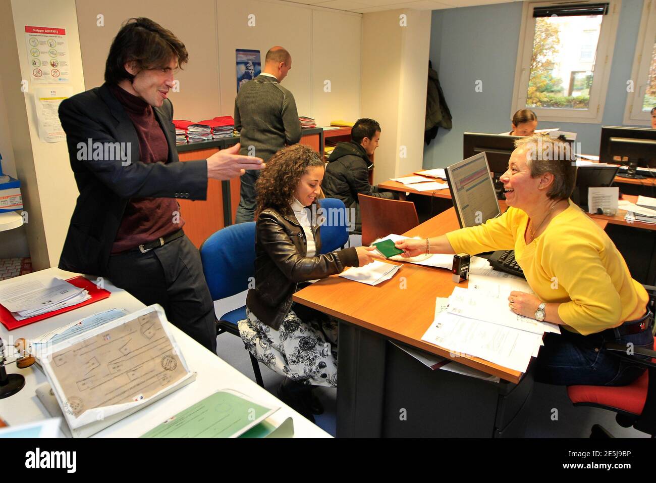 Arno Klarsfeld (L), French lawyer and Head of the French office for  immigration and integration, speaks with an employee as a foreign student  waits for an extension visa at a foreign visas