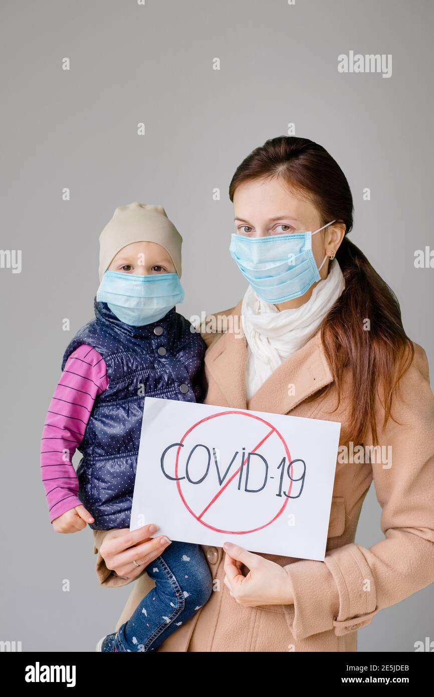 La mère et la fille dans un masque sûr disent arrêter le virus. Famille pendant la quarantaine des épidémies de coronavirus Banque D'Images