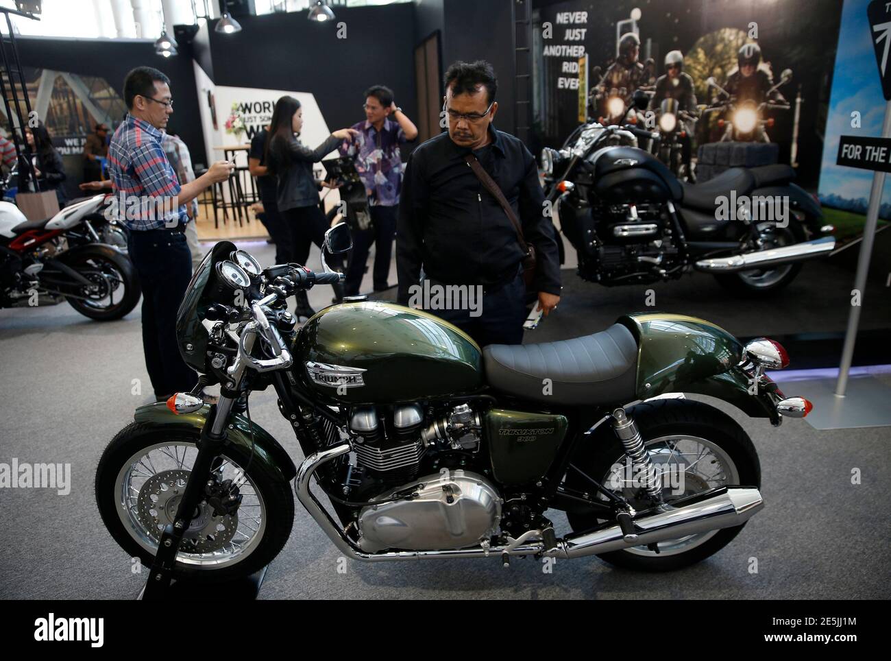 A visitor looks at a Triumph motorcycle on display at the Indonesian