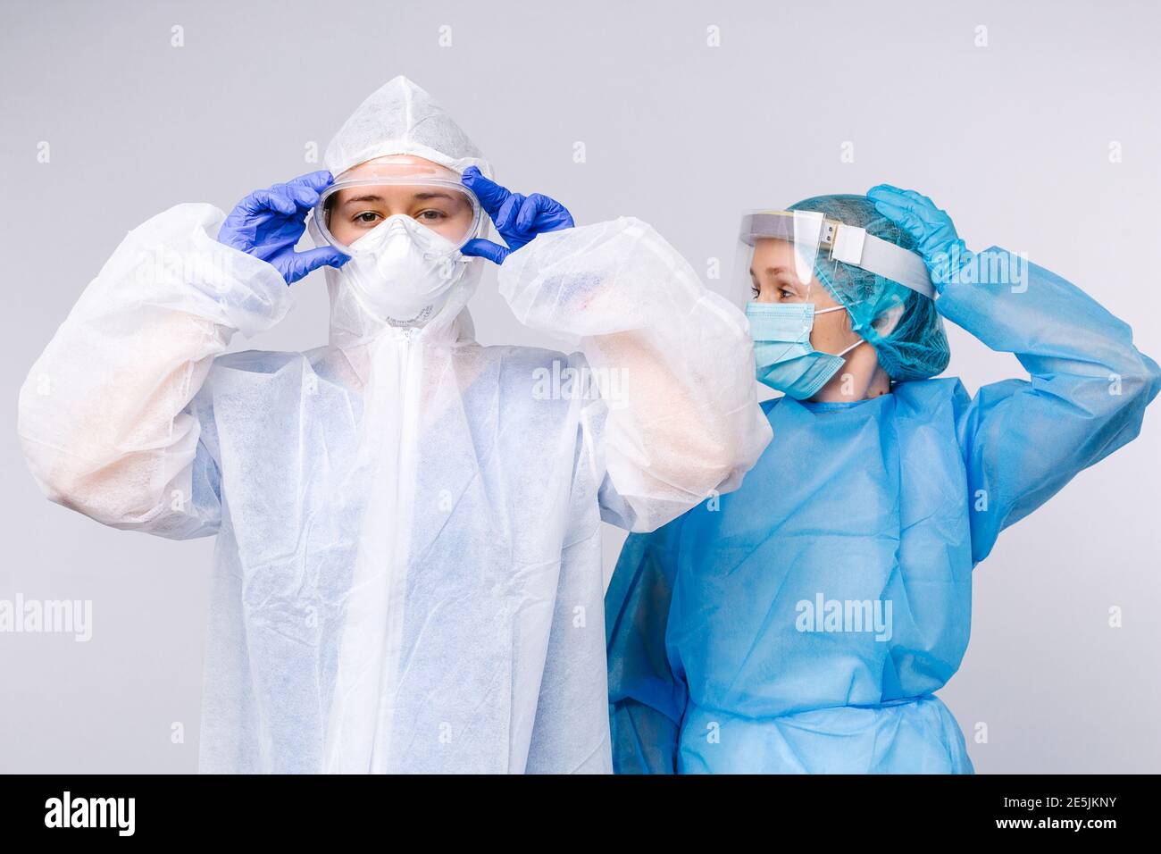 Médecin et infirmière pendant le quart de travail dans l'équipement de protection médicale. Le concept de lutte contre la pandémie et le covid 19. Arrière-plan blanc. Banque D'Images