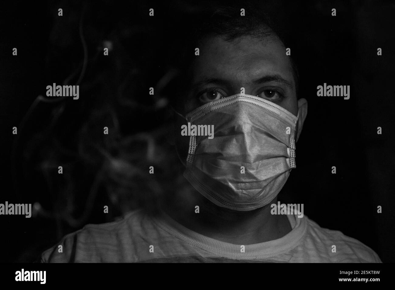 Homme dans l'obscurité portant un masque de protection pour protéger son respirer de la fumée et de la pollution Banque D'Images