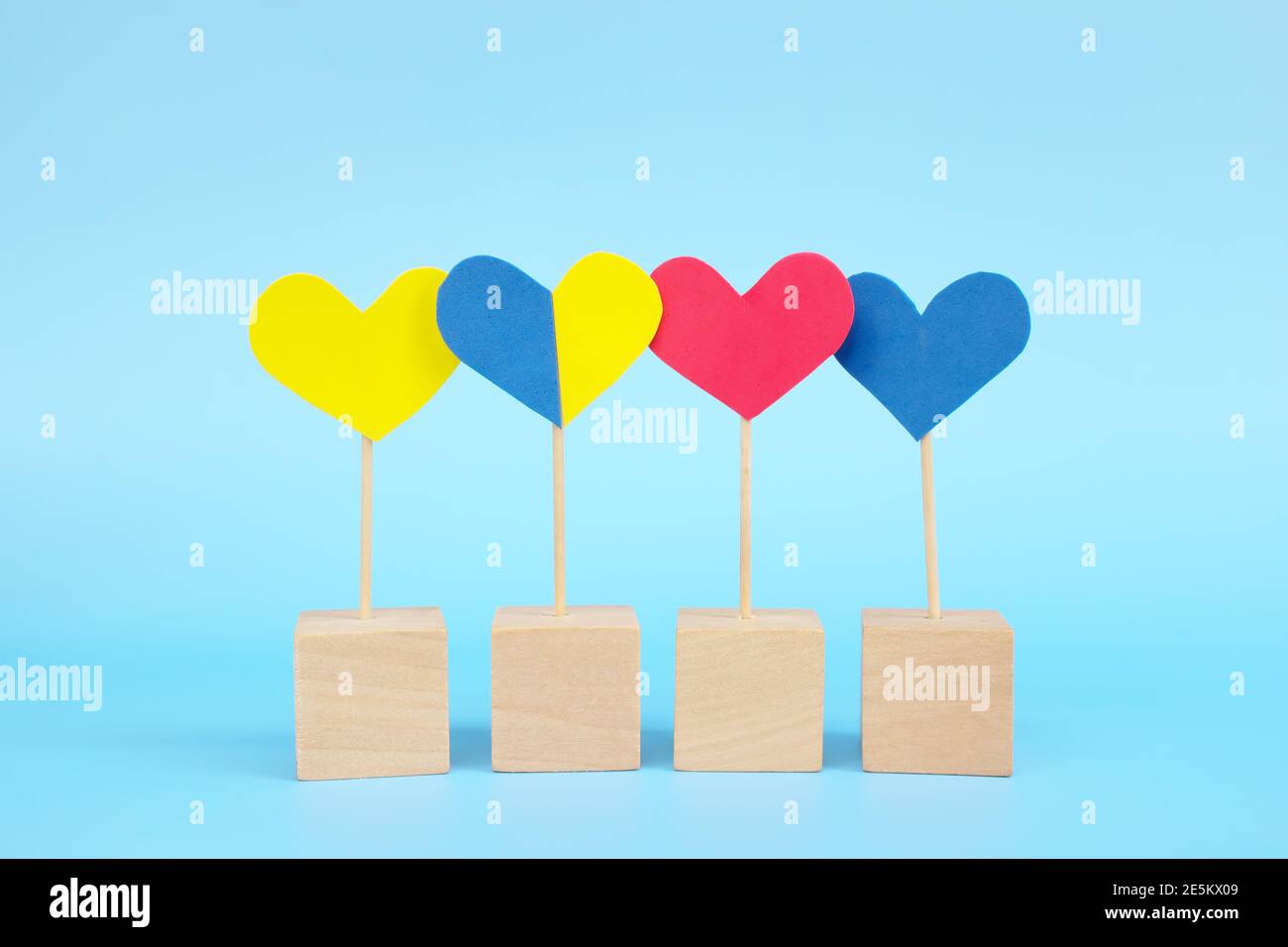 Concept de l'enfant avec le syndrome de Down inclusion sociale, amour, égalité et diversité. Forme de coeur jaune et bleu parmi le groupe multicolore. Banque D'Images