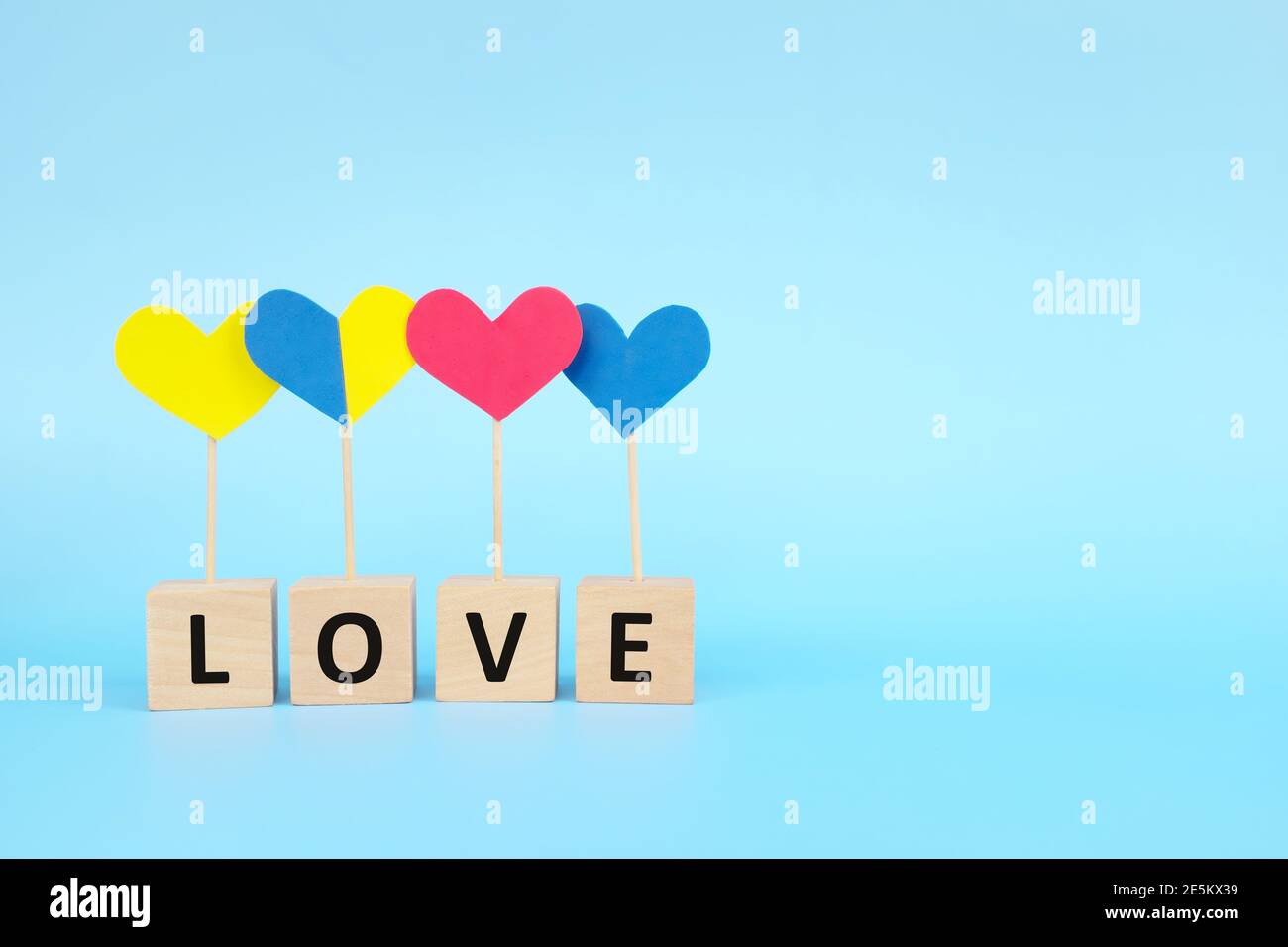 Concept de l'enfant avec le syndrome de Down inclusion sociale, amour, égalité et diversité. Forme de coeur jaune et bleu parmi le groupe multicolore. Banque D'Images