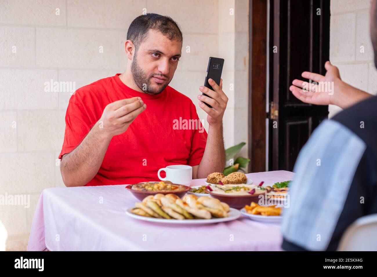 L'homme musulman et son ami mangent ensemble Banque D'Images