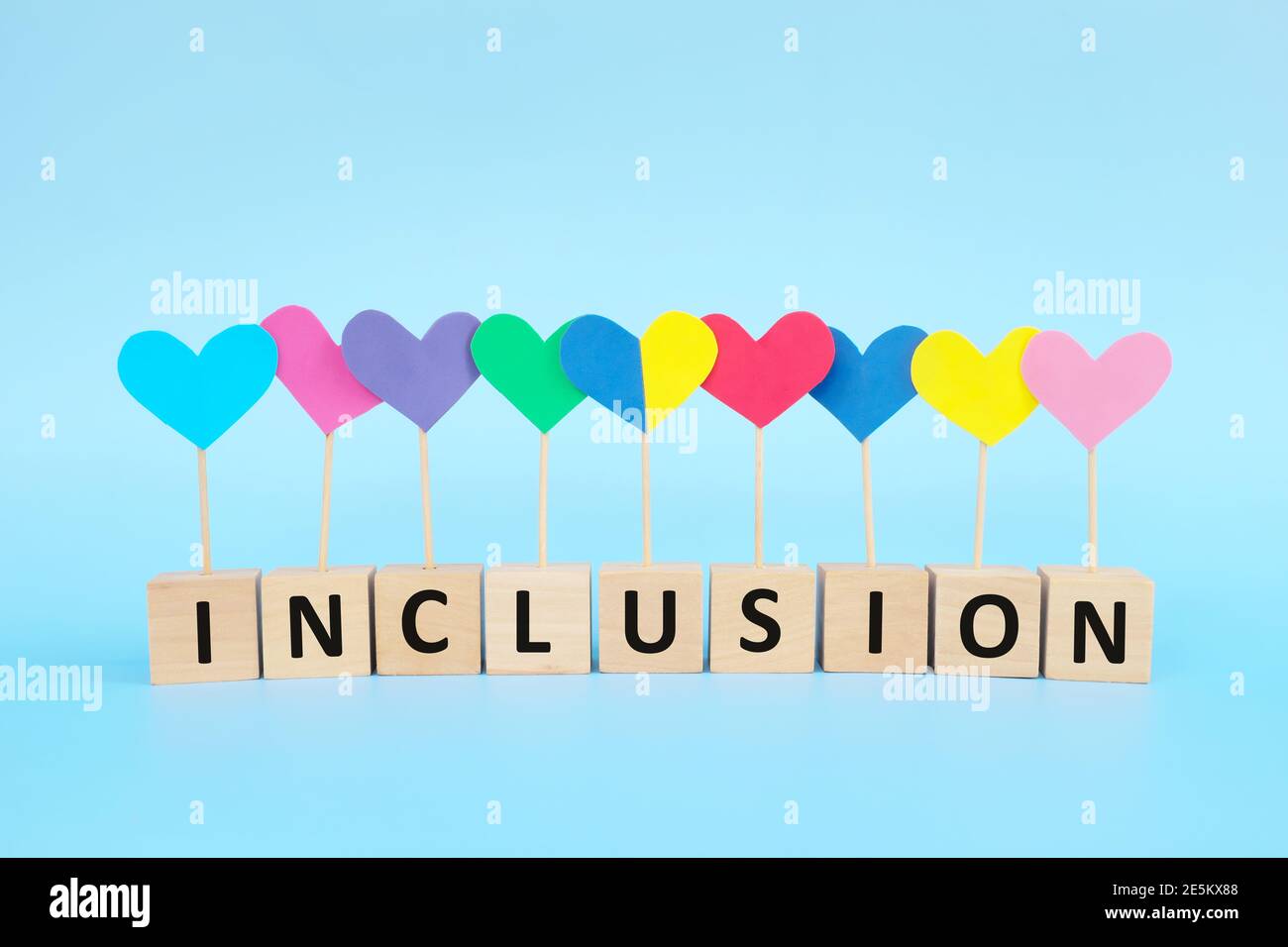 Concept de l'enfant avec le syndrome de Down inclusion sociale, amour, égalité et diversité. Forme de coeur jaune et bleu parmi le groupe multicolore. Banque D'Images