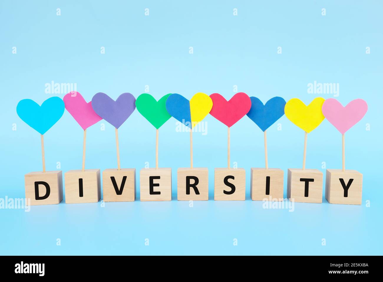 Concept de l'enfant avec le syndrome de Down inclusion sociale, amour, égalité et diversité. Forme de coeur jaune et bleu parmi le groupe multicolore. Banque D'Images