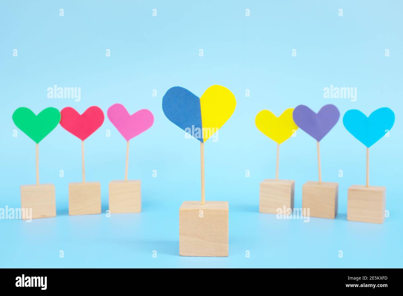 Concept de l'enfant avec le syndrome de Down inclusion sociale, amour, égalité et diversité. Forme de coeur jaune et bleu parmi le groupe multicolore. Banque D'Images