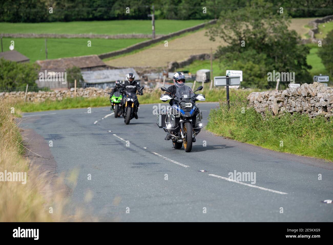 Motocyclistes sur une route rurale à Swaledale près de Muker, se dirigeant sur le col des Buttertubs vers Hawes, Wensleydale. Parc national de Yorkshire Dales, U Banque D'Images