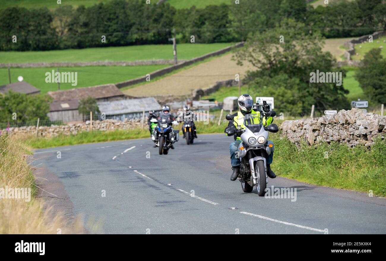 Motocyclistes sur une route rurale à Swaledale près de Muker, se dirigeant sur le col des Buttertubs vers Hawes, Wensleydale. Parc national de Yorkshire Dales, U Banque D'Images