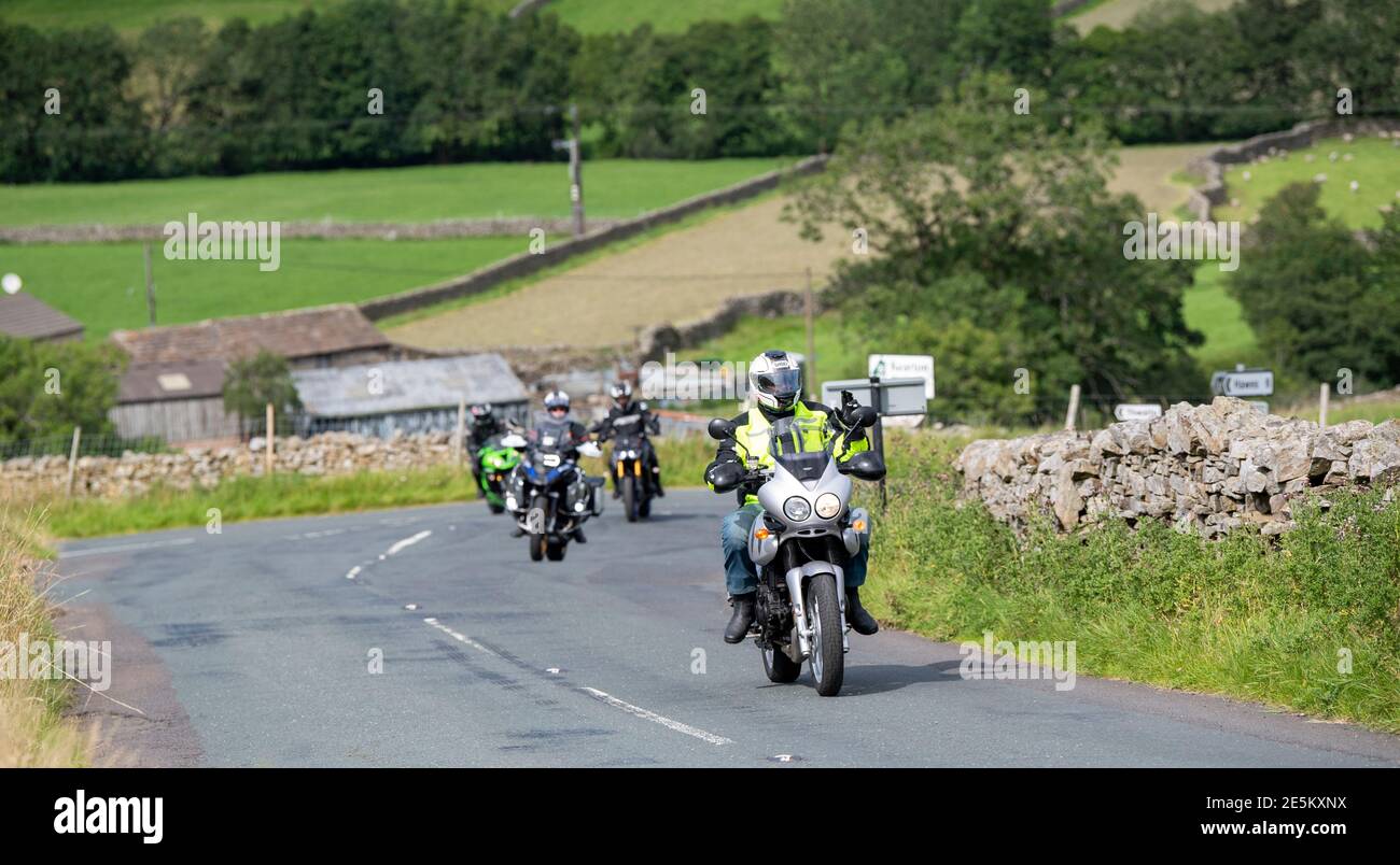 Motocyclistes sur une route rurale à Swaledale près de Muker, se dirigeant sur le col des Buttertubs vers Hawes, Wensleydale. Parc national de Yorkshire Dales, U Banque D'Images