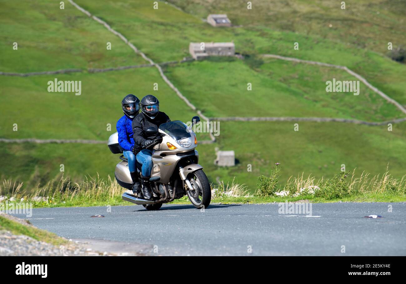 Motocycliste avec pilot sur le col des Butterbeans entre Muker et Hawes dans le parc national de Yorkshire Dales, Royaume-Uni. Banque D'Images