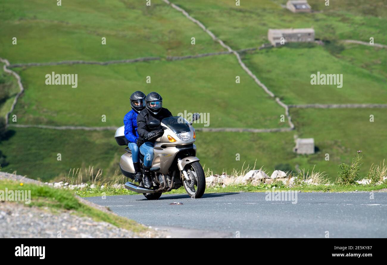 Motocycliste avec pilot sur le col des Butterbeans entre Muker et Hawes dans le parc national de Yorkshire Dales, Royaume-Uni. Banque D'Images