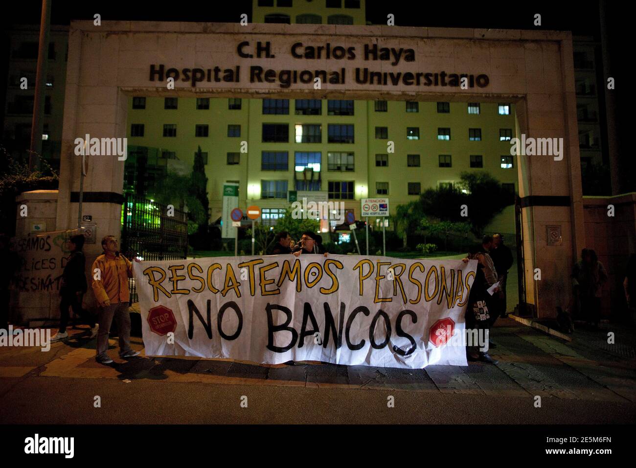 People hold a banner in front of the Carlos Haya hospital during a  demonstration march after two men set themselves on fire, in Malaga,  southern Spain January 4, 2013. Two men, aged