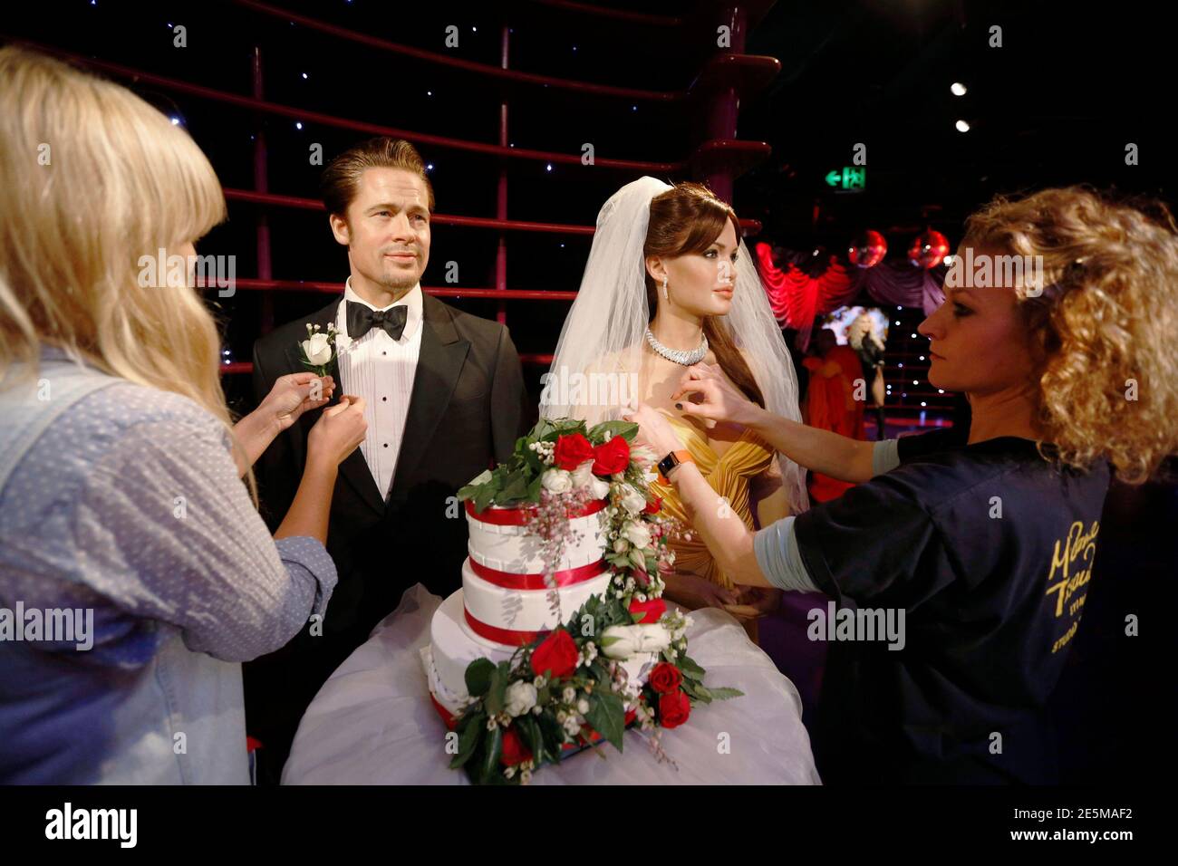 Wax models of actors Brad Pitt and Angelina Jolie are presented with a wedding  cake and a bridal veil for Jolie by staff Kittie Brennan (L) and Zoe  Walton, to celebrate their