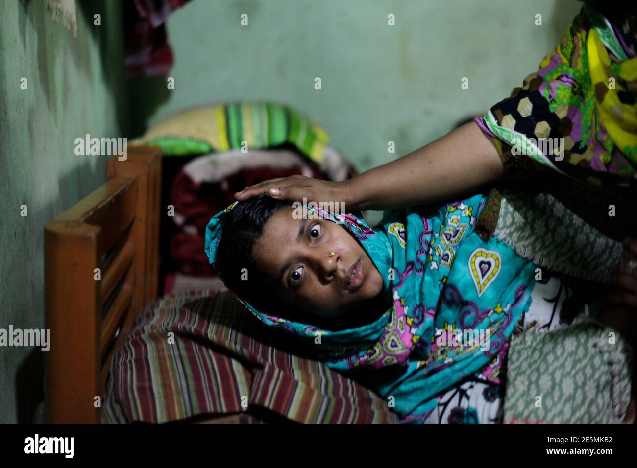 Tahera Begum, 25 ans, qui a survécu à un incendie dévastateur dans une  usine de vêtements, se trouve à l'intérieur de sa chambre de taudis à Savar  le 30 novembre 2012. Begum,