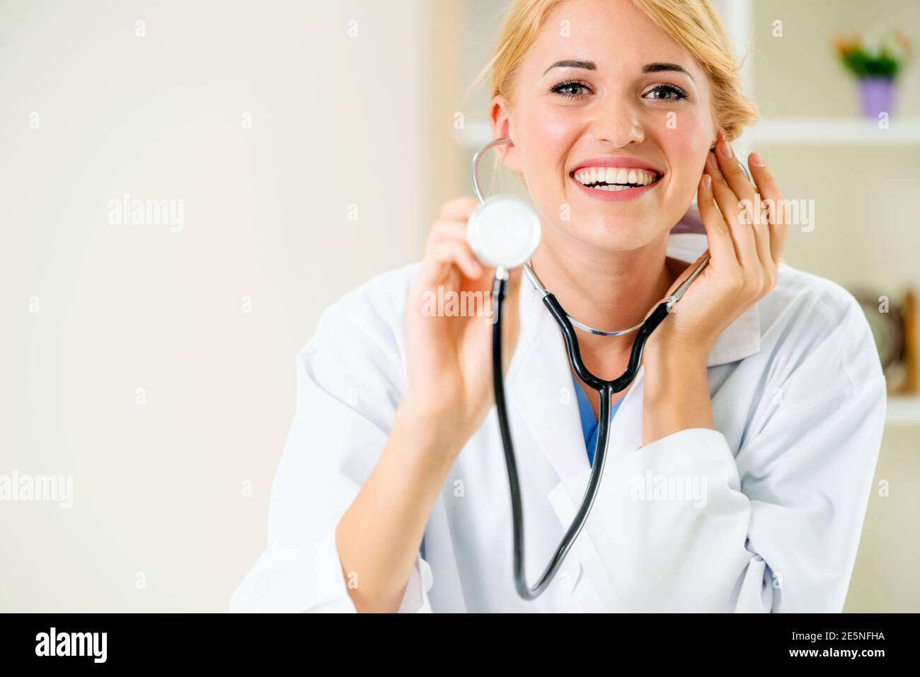 Jeune femme médecin stéthoscope de pointage à l'espace. Au point sélective face aux médecins. Soins médicaux concept. Banque D'Images