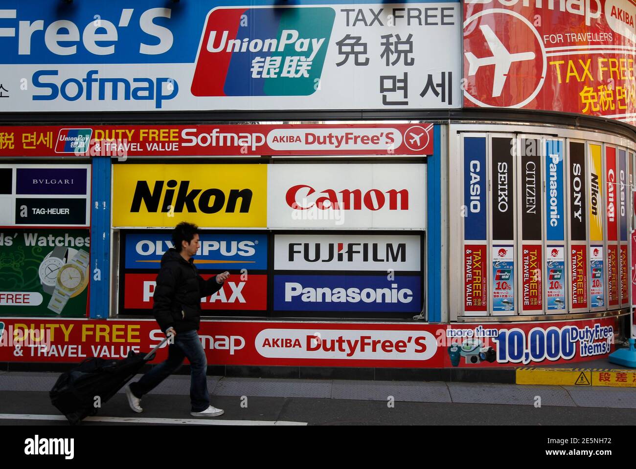 A Man Walks Past An Advertisement Board Featuring Chinese Bank Card Unionpay To Attract Chinese Shopper At The Electronic Shopping District Akihabara In Tokyo January 21 11 Retailers Across Asia Are Poised