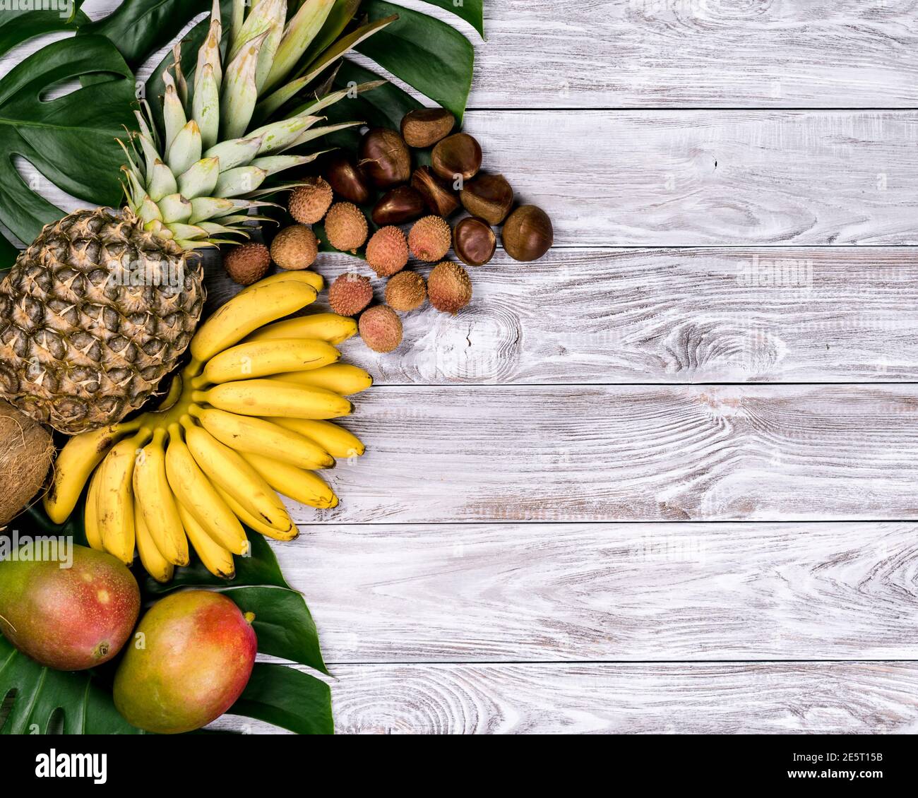 Fruits tropicaux frais sur bois. Vue de dessus les bananes, ananas, noix de coco, la mangue, le litchi châtaignes Banque D'Images