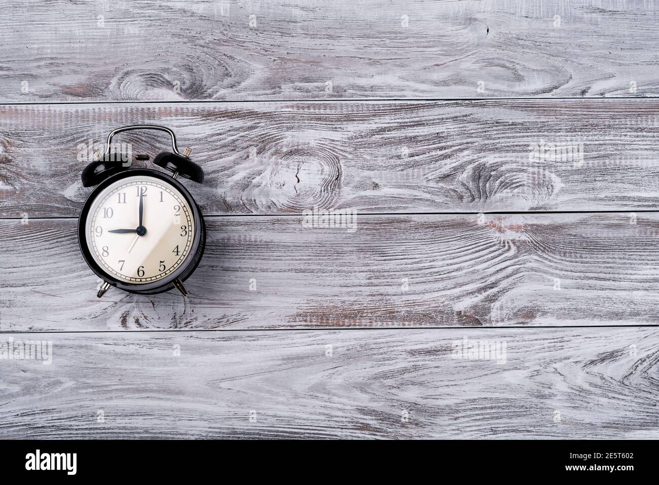 Réveil montrant 5 heures sur fond de bois. Banque D'Images