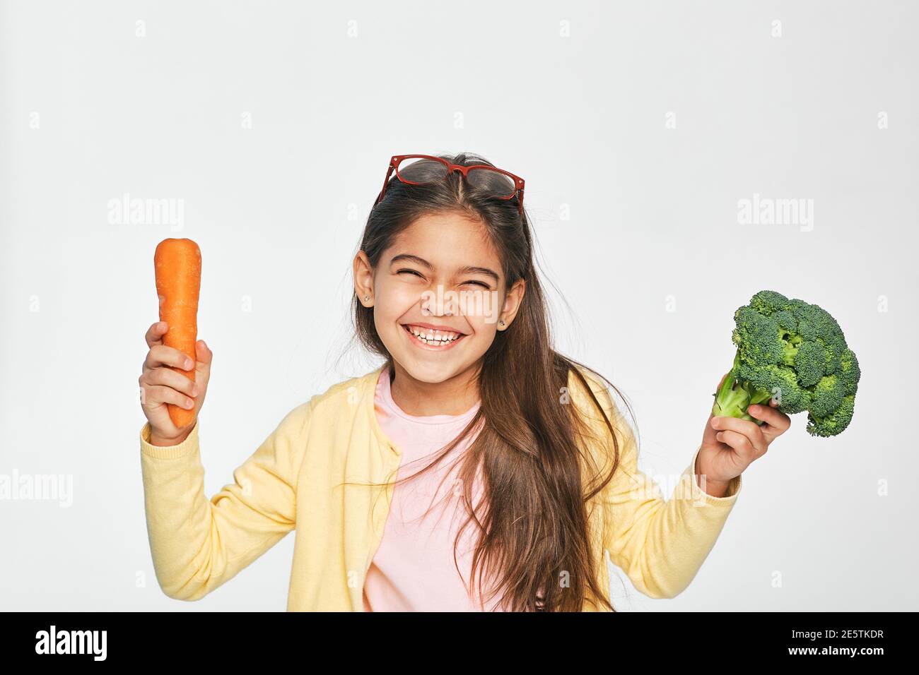 La femme asiatique est très heureuse de manger des légumes sains. Les carottes et le brocoli sont excellents pour la santé des enfants Banque D'Images