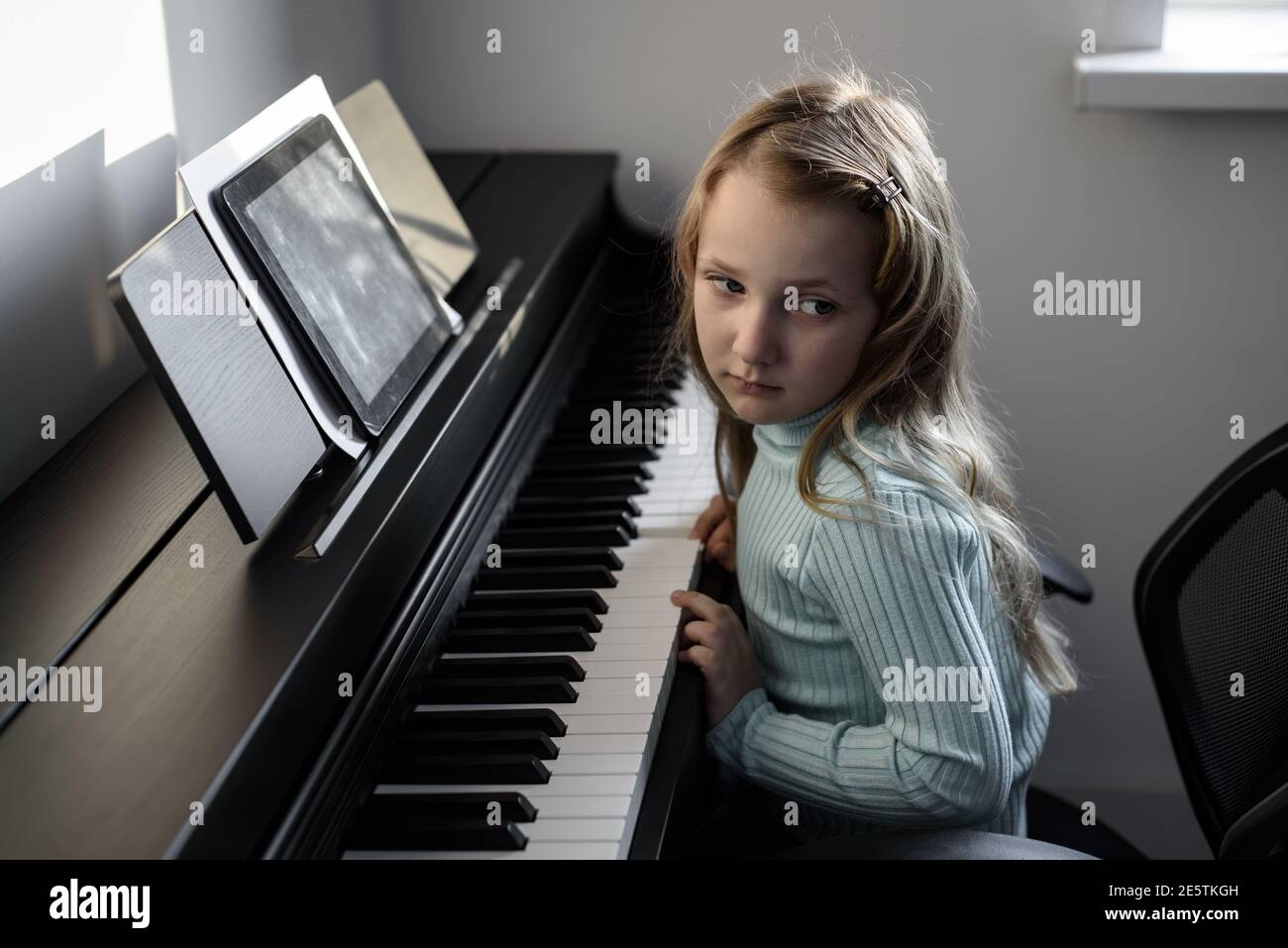 La triste fille ne veut pas jouer le piano. Problèmes d'apprentissage à  distance Photo Stock - Alamy
