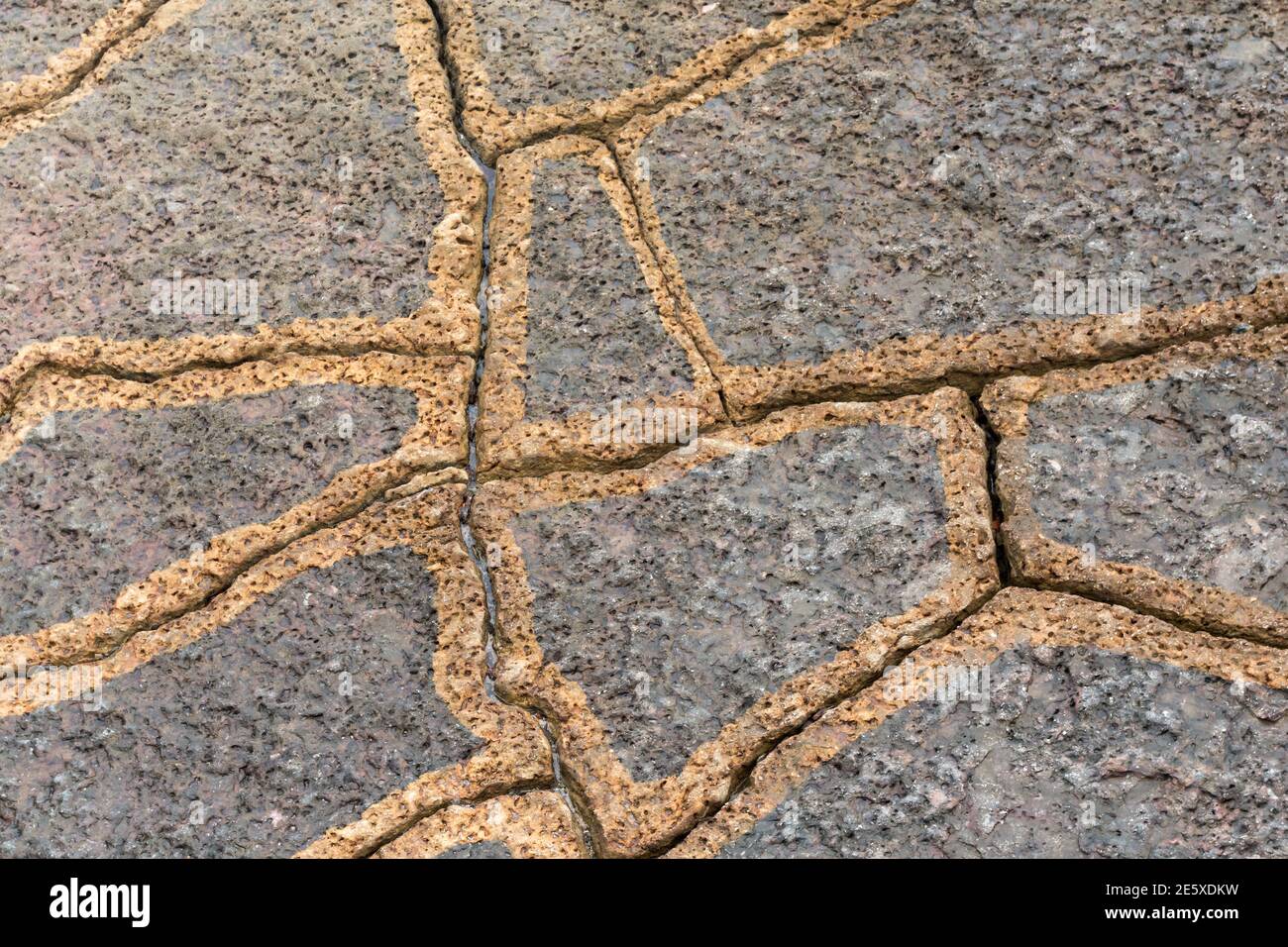 Gros plan des roches érodées par la mer formant fragmentée motifs de ligne en nuances de marron et de gris sur le La côte de Sintra au Portugal Banque D'Images