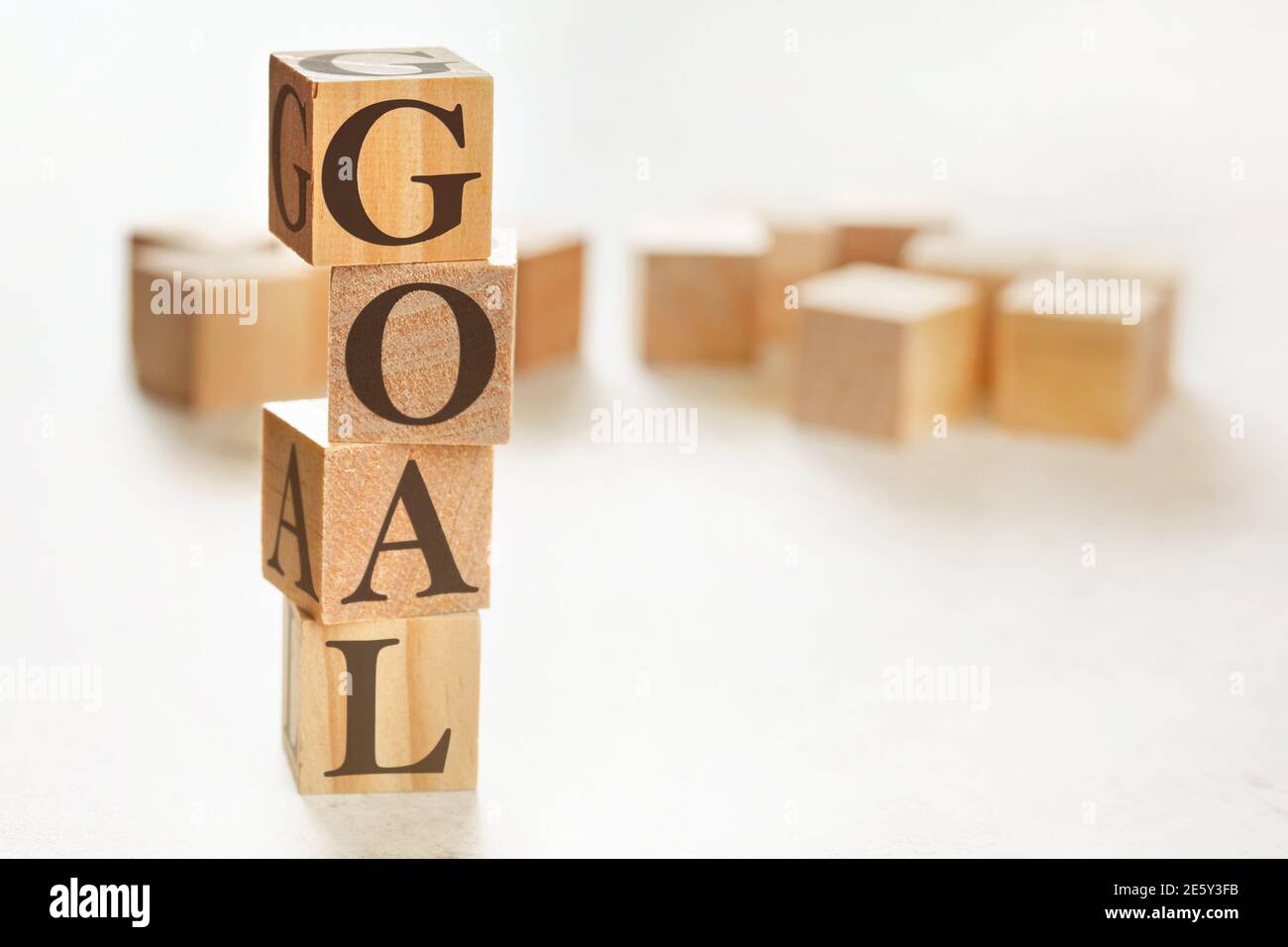 Quatre cubes en bois disposés en pile avec le mot OBJECTIF sur eux, espace pour le texte / l'image dans le coin inférieur droit Banque D'Images